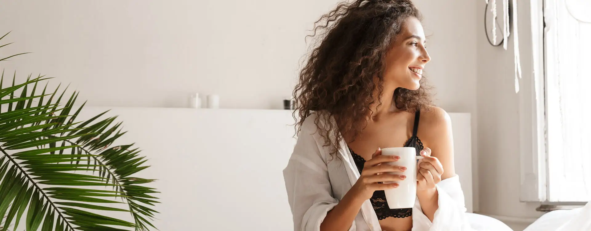 Woman smiling staring off holding a cup